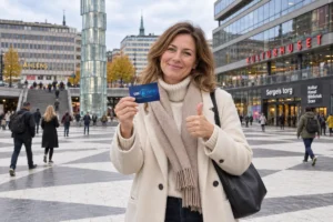 En person visar ett SkimSkydd RFID-skyddskort och gör tummen upp vid Sergels torg i Stockholm
